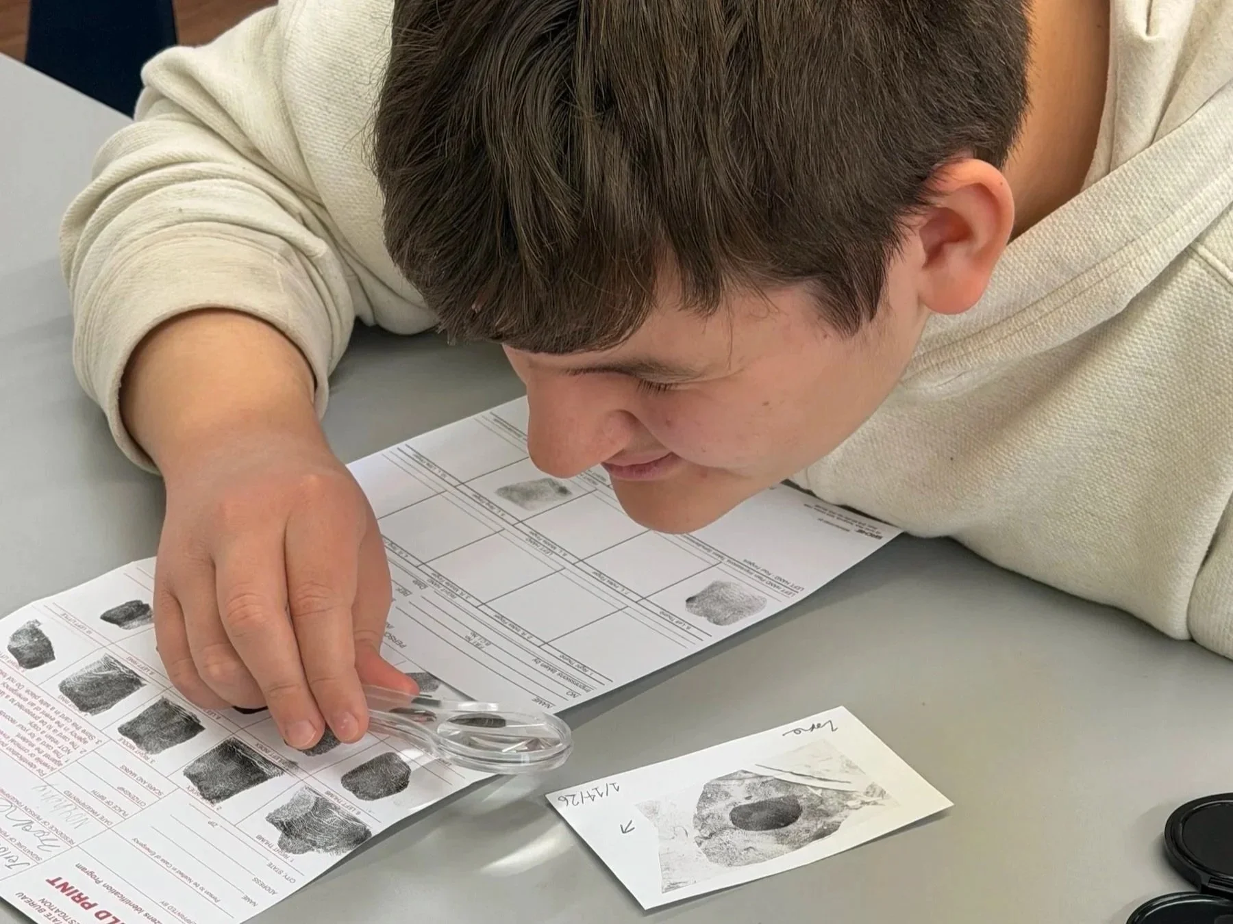 Student examining a fingerprint in a forensics project
